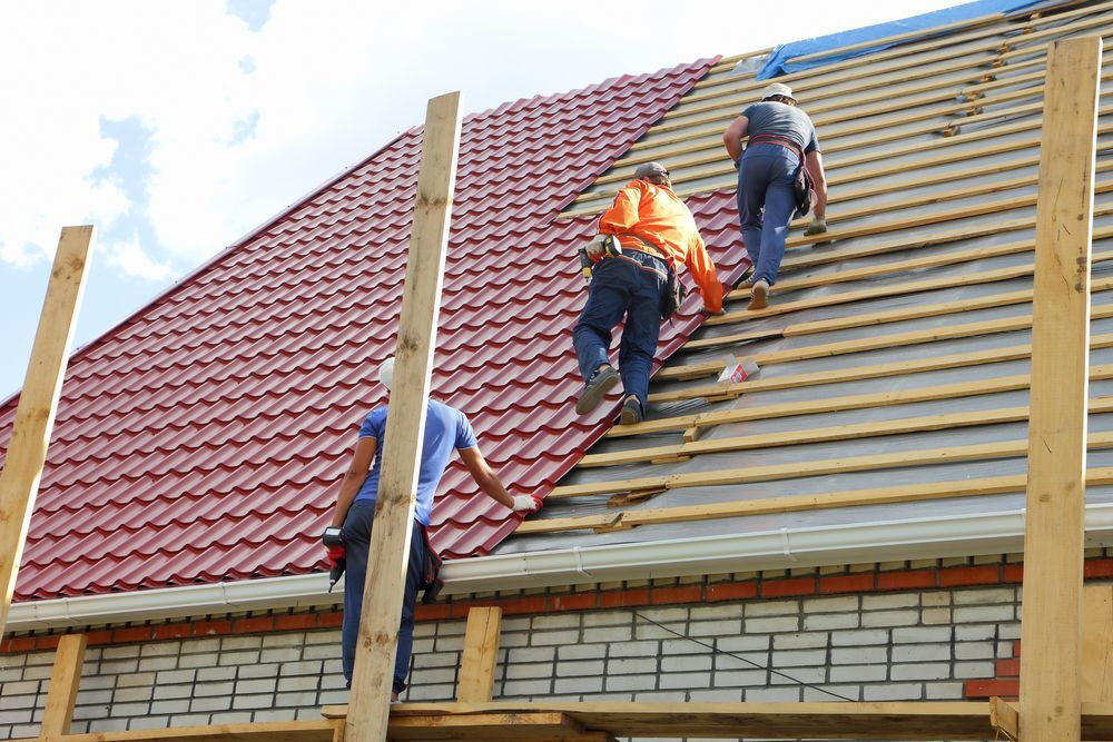 Dakdekkers werken samen op een pannendak