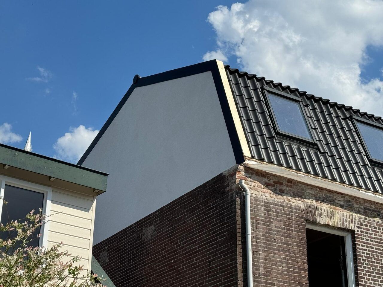 Volledig vernieuwd pannendak met zwarte pannen en dakramen